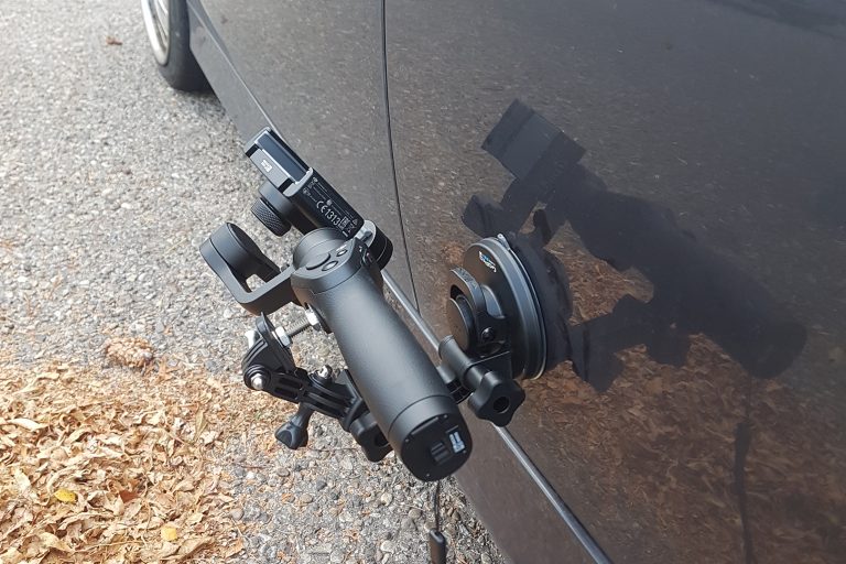 Professional camera setup mounted on a vehicle for automotive photography and videography.