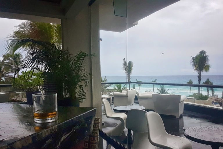 Ocean view lounge with seating and palm trees, overlooking the sea and sky.