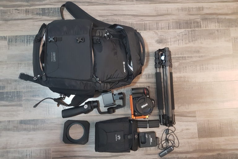 Backpack with camera gear and tripods for professional photography.