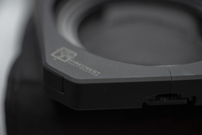 Close-up of black wireless Bluetooth headphones with sleek design and logo, on a neutral background.